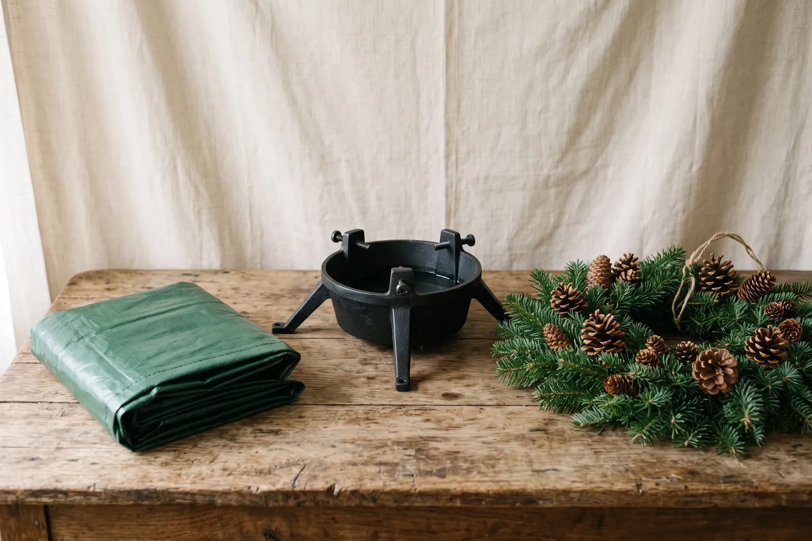 Kerstboomvoet met waterreservoir en een kerstkrans van vers groen
